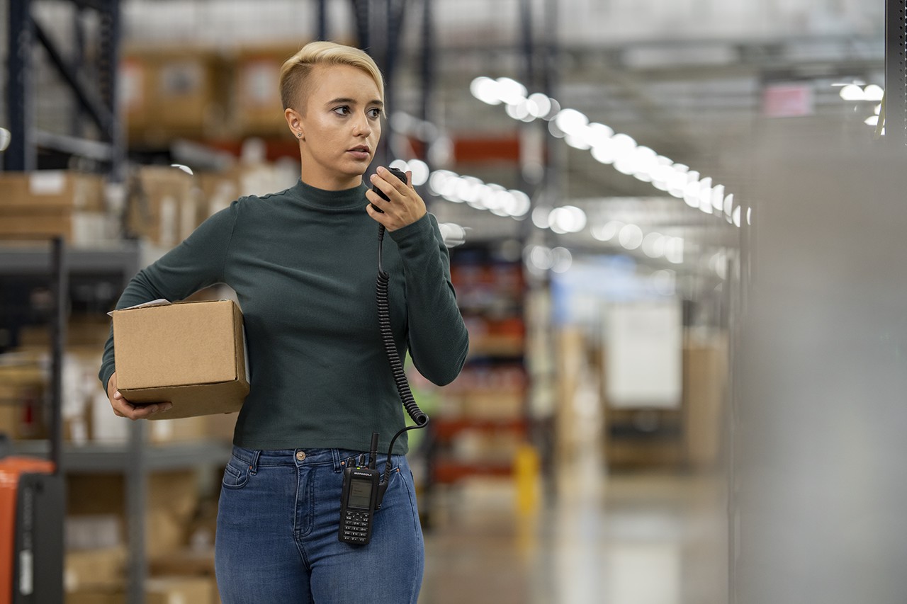 woman using motorola two-way radio to communicate with team